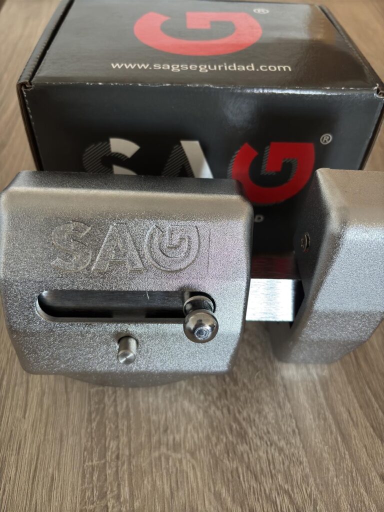 Primer plano de un cerrojo SAG de alta seguridad junto a su caja original, resaltando su diseño robusto y calidad premium, ideal para proteger hogares y negocios.