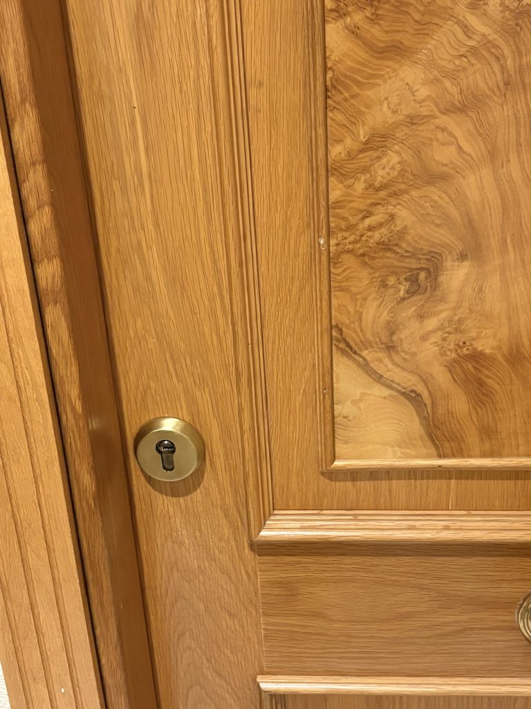 Cerradura antigua dorada en una puerta de blindada en Valladolid con escudo de seguridad obsoleto y bombín de perfil europeo vulnerable al bumping